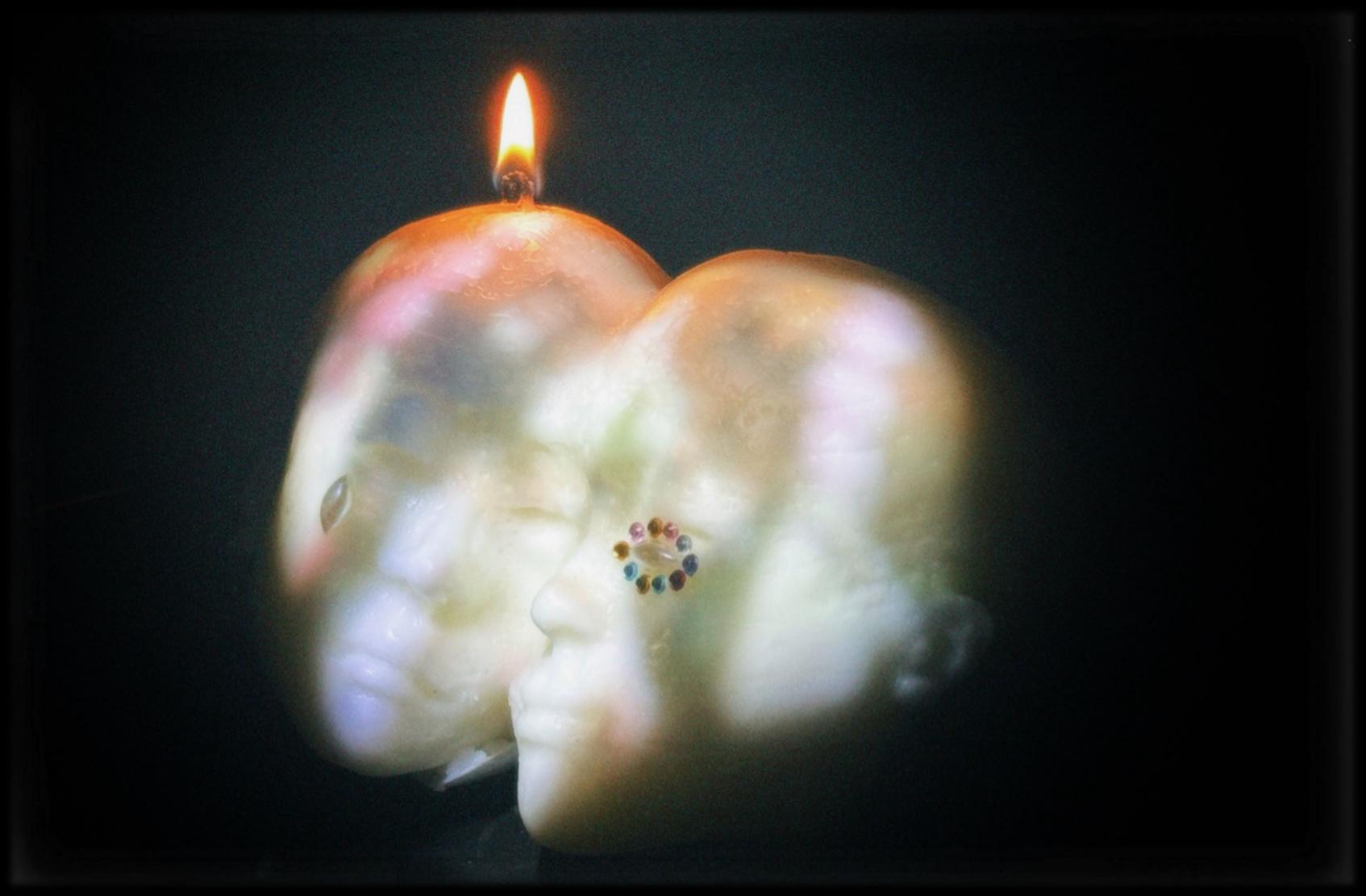 Instant-02 — a candle cast from a 3D-printed twin-face model, lit.